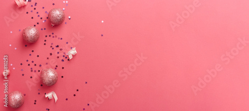 Golden christmas decorations on trendy pink background. Christmas New year or party banner. Copy space