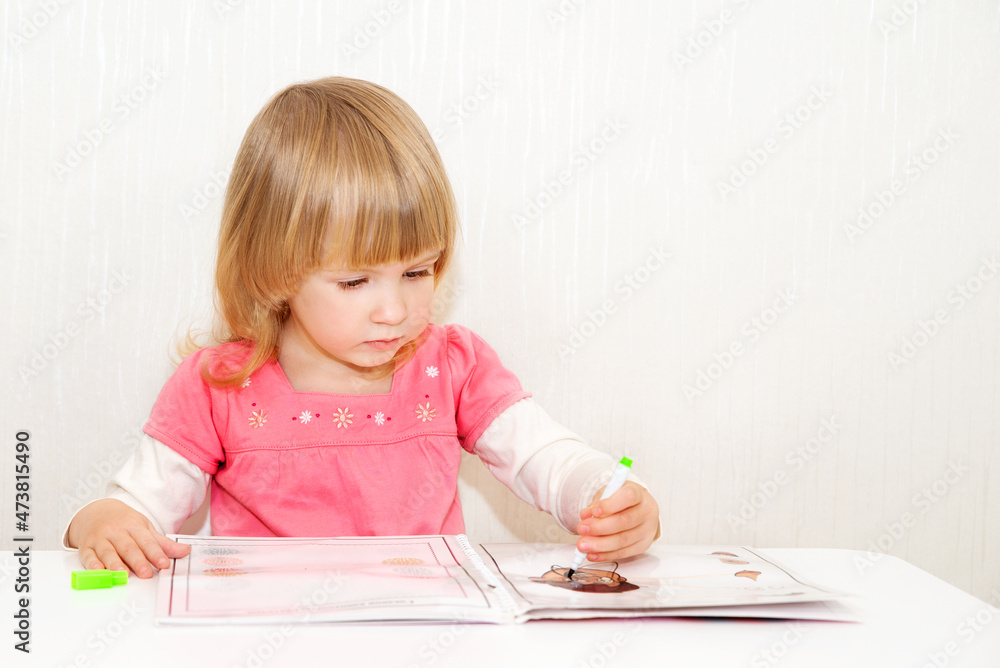 Beautiful toddler girl draws with a pencil. Children's creativity concept. Beautiful toddler girl draws with a pencil. Children's creativity concept.