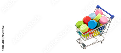shopping cart with Recycled Multicolored Plastic Bottle Caps on white background with copy space, banner styled