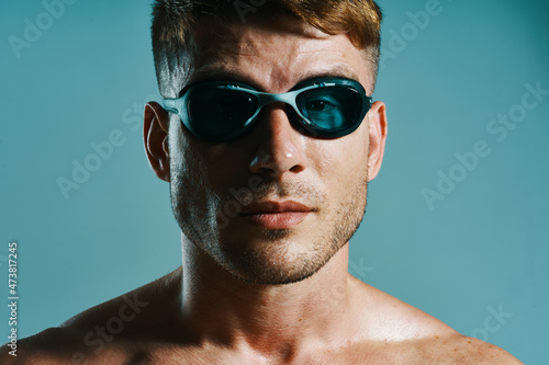 man in swimming goggles athlete swimmer blue background © VICHIZH