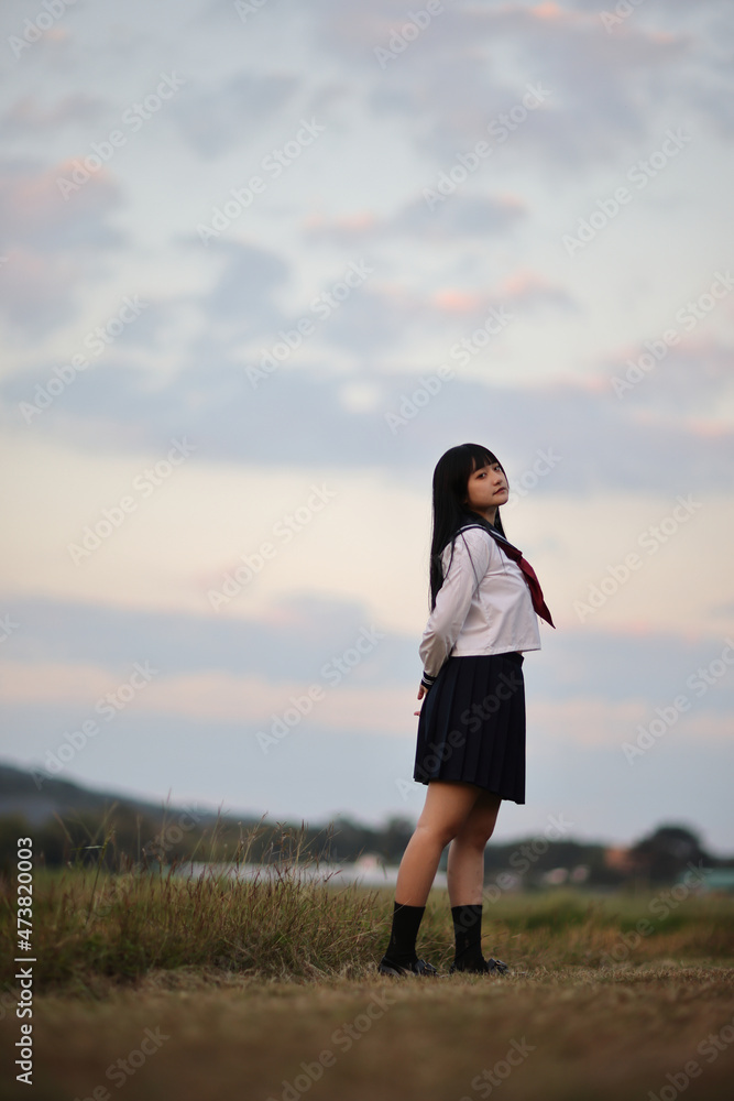Asian High School Girls student looking at camera in countryside with sunrise