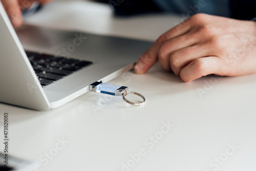 Businessman using laptop with inserted USB stick on desk photo