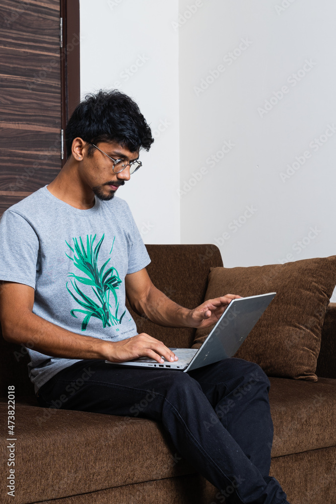 young Indian boy working on his laptop and work from home