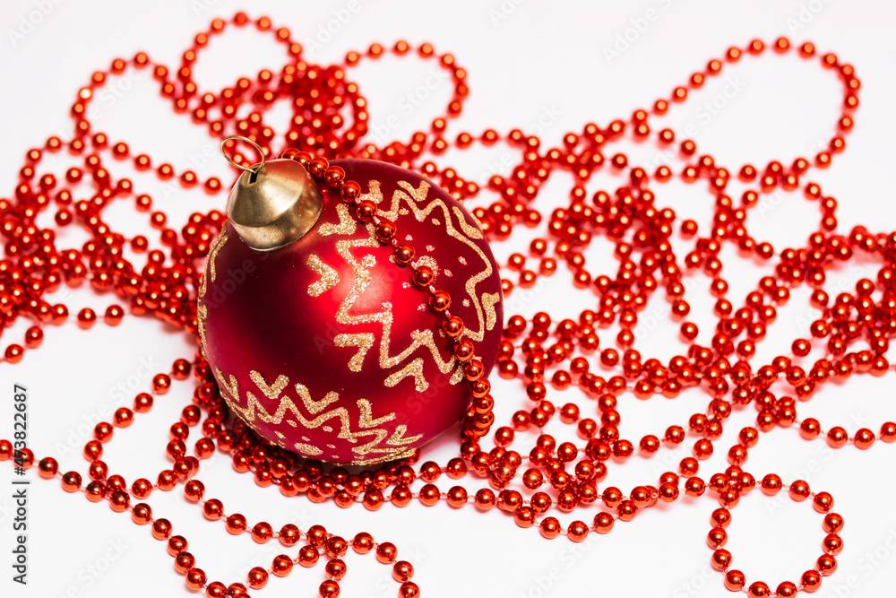 red christmas ball and garland of beads on white