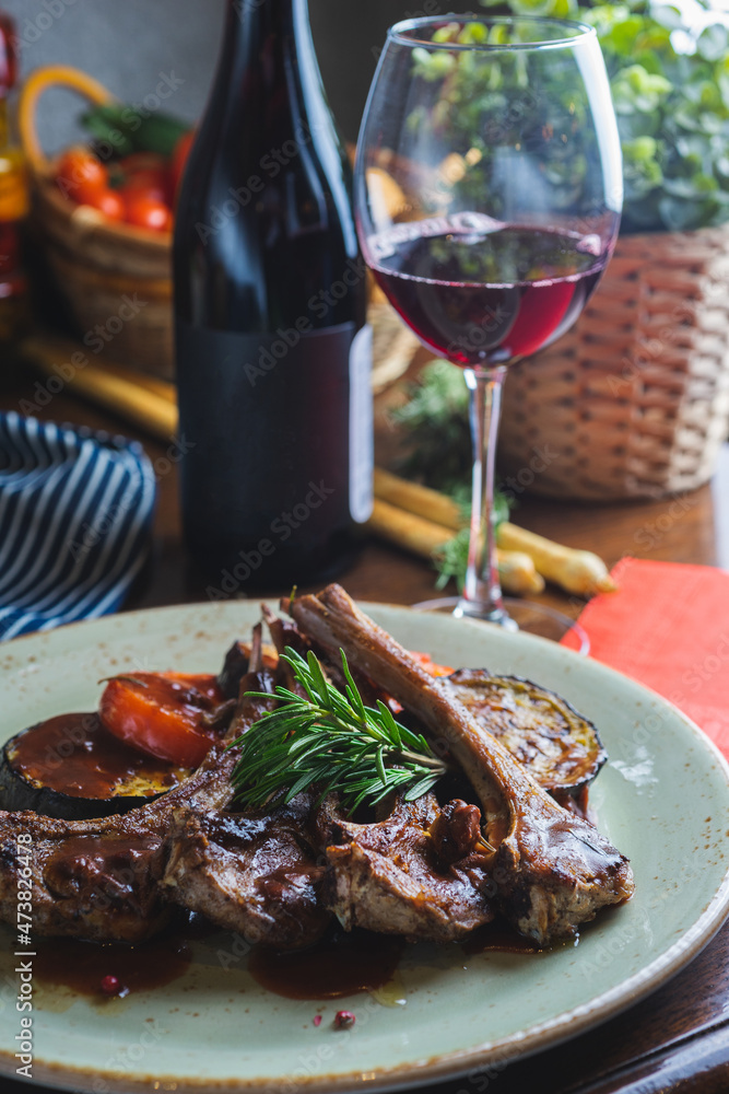 Fried ribs with a glass of red wine on a table in a restaurant close-up Fried ribs with a glass of red wine on a table in a restaurant close-up