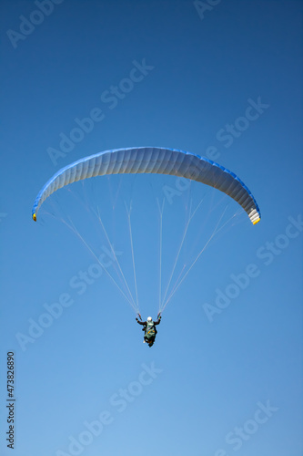 Paraglider flying in the mountain. The sea in the background in the photograph