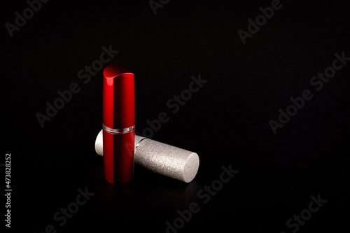 Silver and red lipstick bottle side-view on black background
