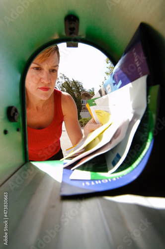 Woman getting mail view from inside mailbox.