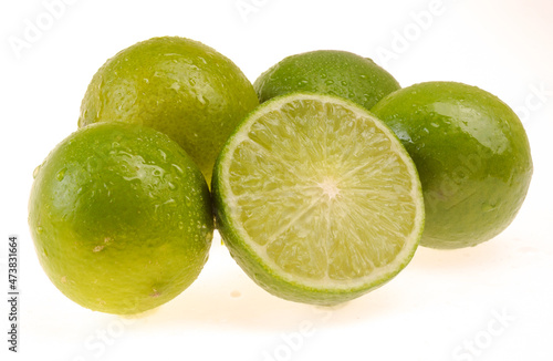Lemons being one cut in half on white background.