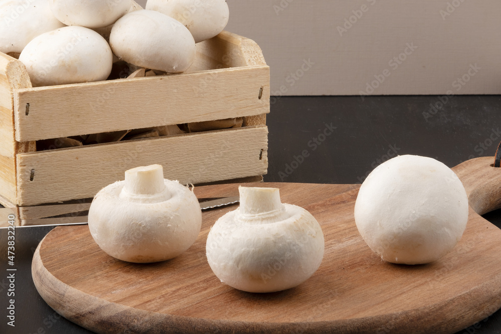 Champgnon mushrooms on cutting board and it box. Champgnon mushrooms on cutting board and it box.
