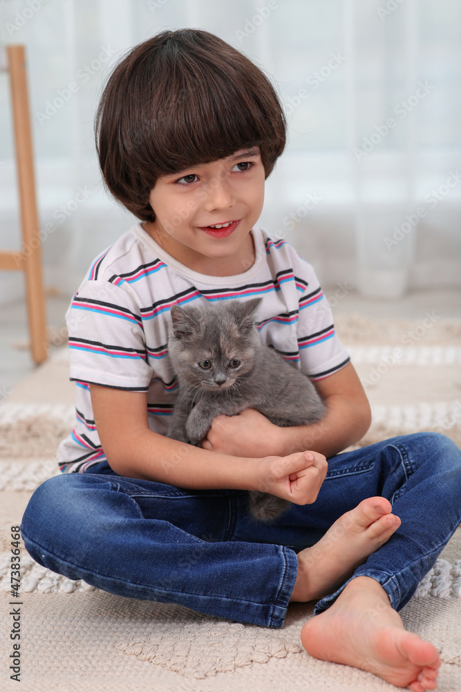 Cute little boy with kitten on floor at home. Childhood pet Cute little boy with kitten on floor at home. Childhood pet