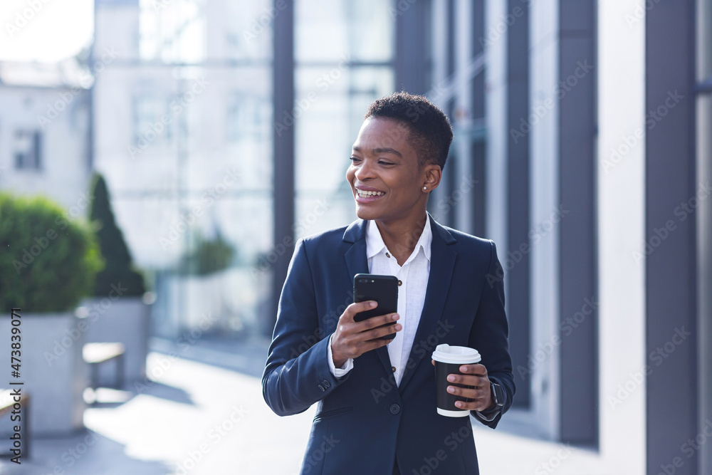 Business woman enjoys cellphone fun and smiling, African American boss businesswoman outside office in business suit Business woman enjoys cellphone fun and smiling, African American boss businesswoman outside office in business suit