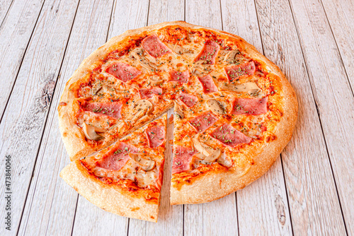 Family-size pizza with cooked ham, mozzarella cheese, oregano and sliced mushrooms