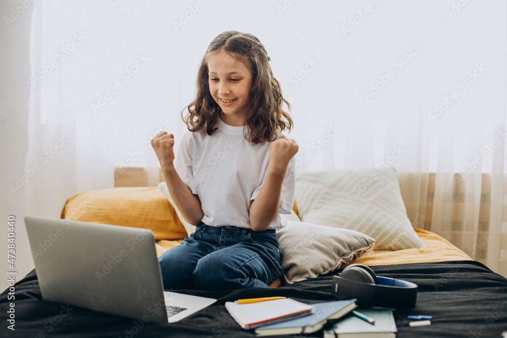 Obraz premium School girl studying at home, distant learning