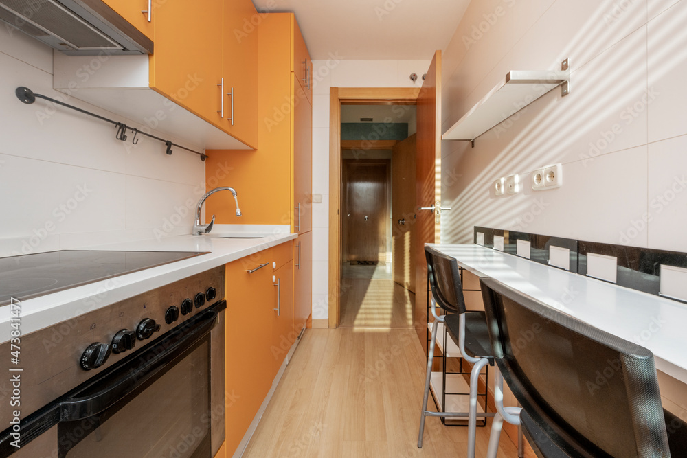 Kitchen with orange cabinets, white countertop and white appliances in vacation rental apartment Kitchen with orange cabinets, white countertop and white appliances in vacation rental apartment