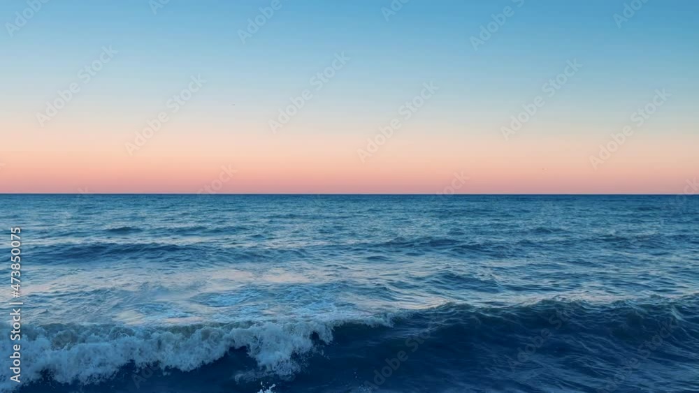 Ocean waves on sunset. Tranquil scene after the sunset with ripple waves Ocean waves on sunset. Tranquil scene after the sunset with ripple waves