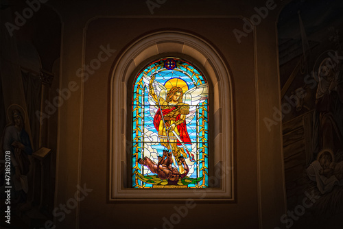 stained glass window with saint michael who kills a demon