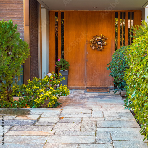 Christmas wreath decorated house entrance natural wood doors, Athens, Greece.