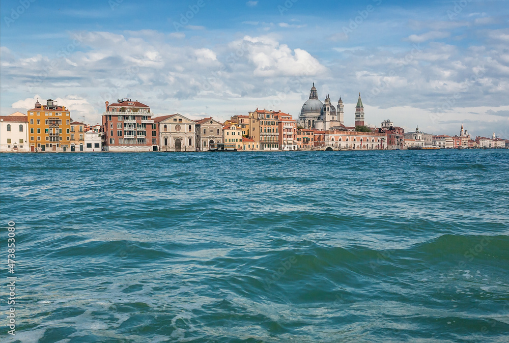 Towers, mansions and lagoon of Venice under blue sky. Ancient italian city with water canals and historical landscape