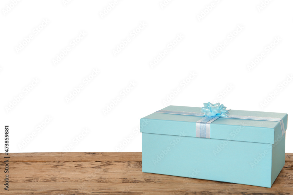 Fototapeta premium Light blue gift box with bow on wooden table against white background, space for text