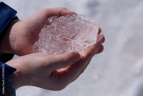 Ice crystal in hand. Rays of sunlight pass through an ice crystal.