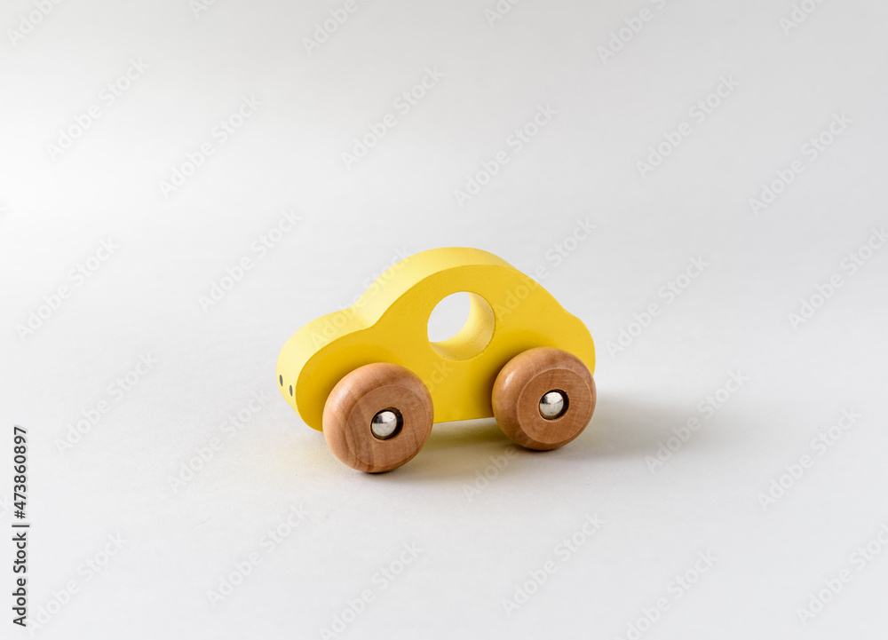 Yellow wooden toy car on a white seamless background Yellow wooden toy car on a white seamless background