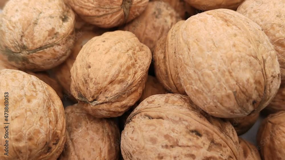 Many walnuts are rotating. The texture of nuts in close-up. Many walnuts are rotating. The texture of nuts in close-up.