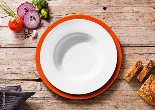 Vegetables and bread near empty bowl