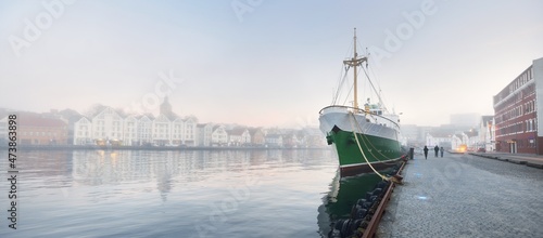 Green training ship moored to a pier in a city center. Stavanger embankment, Norway. Travel destinations, sightseeing, landmark, tourism, cruise, regatta, expedition, research, work, traditional craft photo