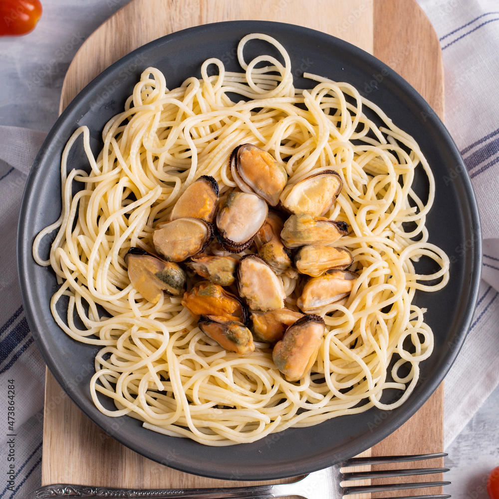 Pasta with seafood in a creamy sauce. Homemade Italian food, top view. Mussel salad on a ceramic plate. Food for every day. Mediterranean diet. Pasta with seafood in a creamy sauce. Homemade Italian food, top view. Mussel salad on a ceramic plate. Food for every day. Mediterranean diet.