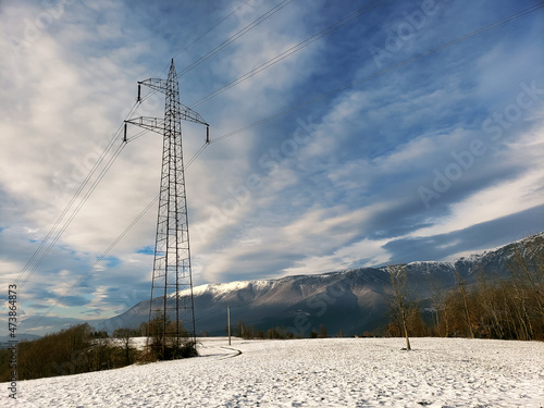 Frost and snow covered power lines during very cold winter against sky.