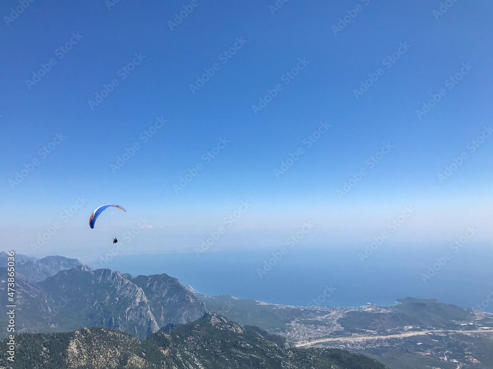 Paragliders flying from a top of Tahtali mountain near Kemer, Antalya Province in Turkey. Concept of active lifestyle and extreme sport adventure Paragliders flying from a top of Tahtali mountain near Kemer, Antalya Province in Turkey. Concept of active lifestyle and extreme sport adventure