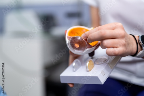 Ophthalmologist or surgeon holds an eye, eyeball prosthesis in hands . Concept photo for ocular prosthesis, diagnosis treatment of ophthalmic diseases, surgical operations on eyes. Closeup