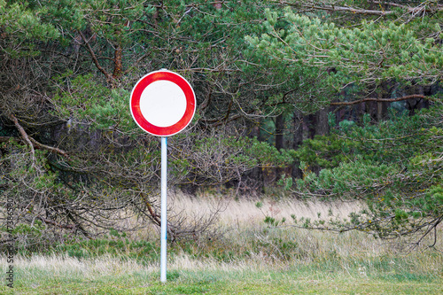 red and white road sign is forbidden to drive on a green forest background