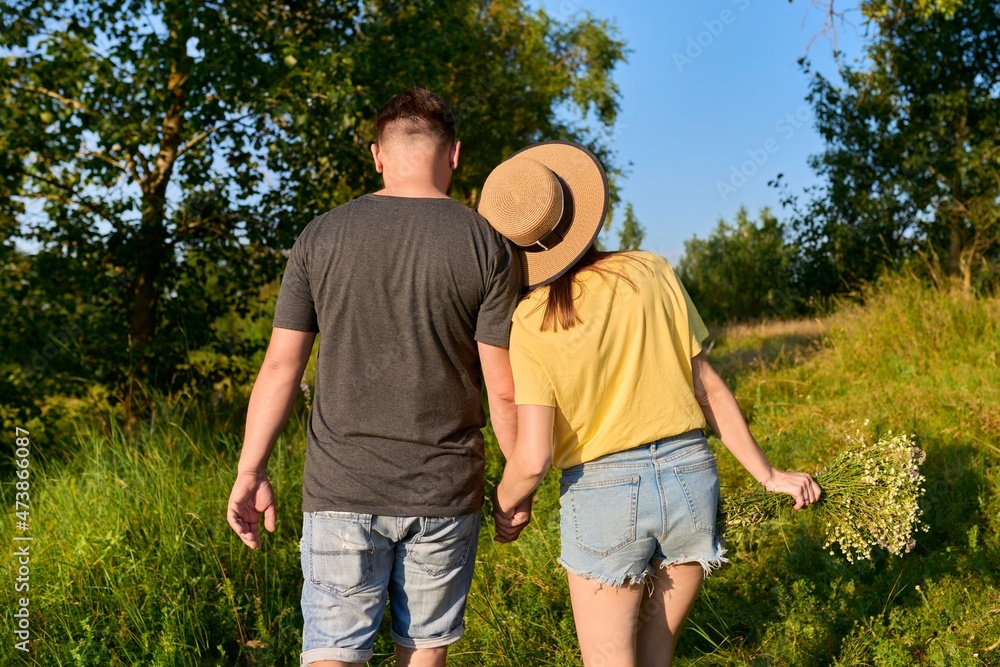 Happy romantic middle age couple, walking together holding hands, back view Happy romantic middle age couple, walking together holding hands, back view