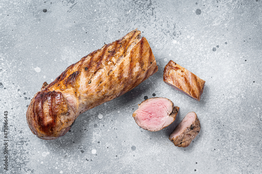 BBQ roasted pork tenderloin fillet meat. Gray background. Top view. Copy space