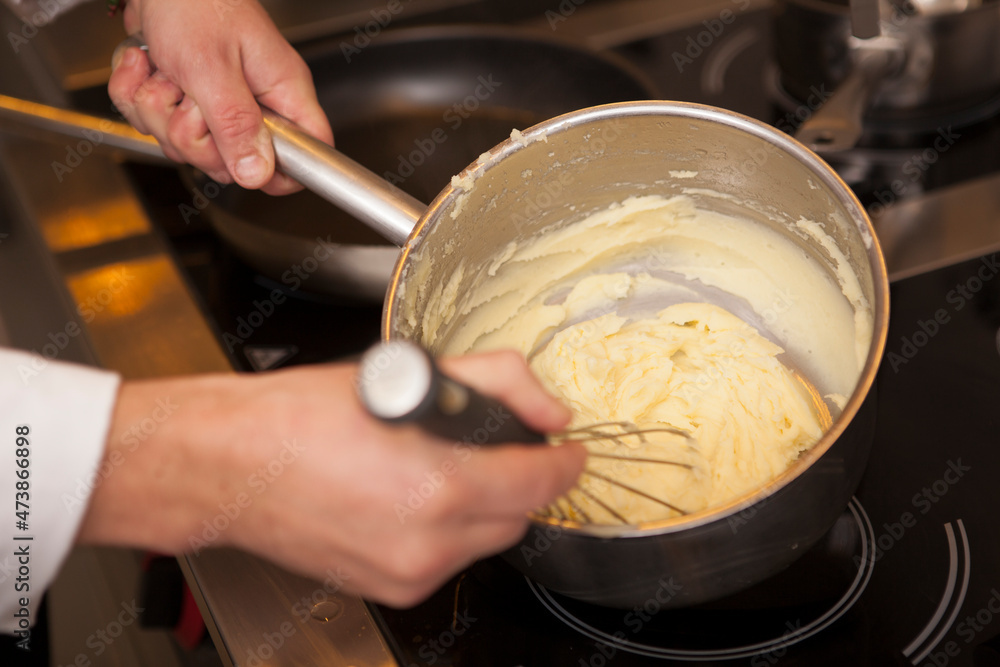 Close up of a chef whisking mashed potatoes in a pot Close up of a chef whisking mashed potatoes in a pot