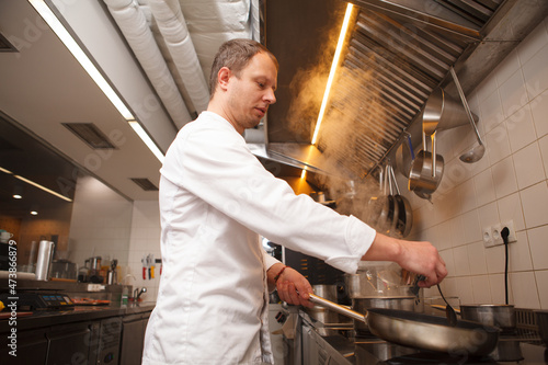 Low angle shot of a professional chef cooking using frying pan