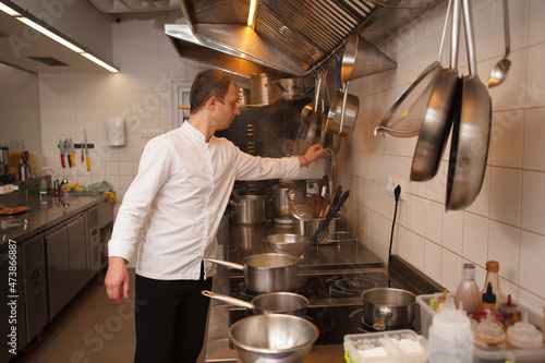 Chef working at the restaurant kitchen, using kitchenware