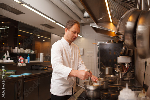 Male chef melting butter, cooking at restaurant kitchen, copy space