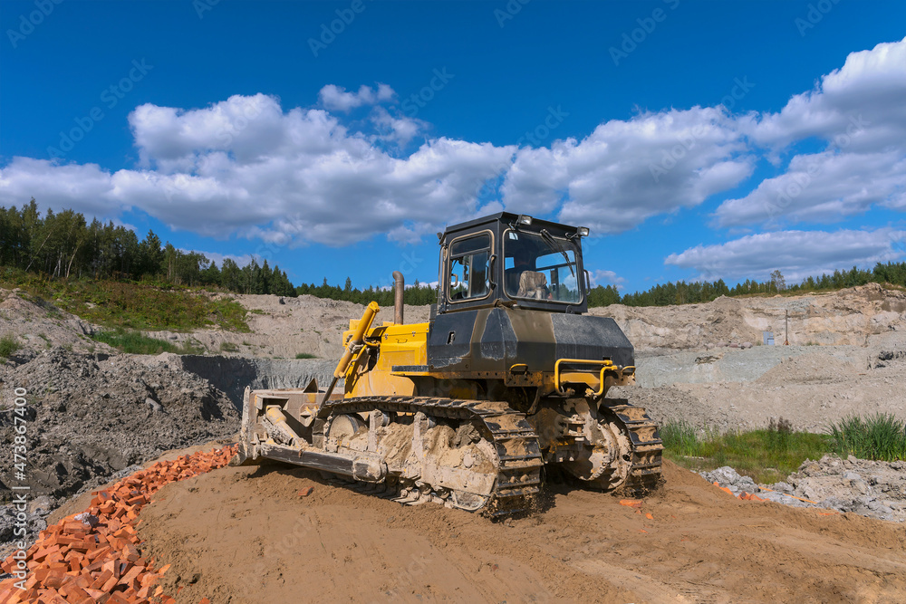 the process of leveling the soil with a modern bulldozer during the construction of a dirt road