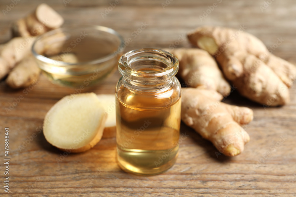 Ginger essential oil in bottle on wooden table Ginger essential oil in bottle on wooden table
