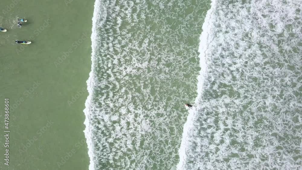 Aerial overhead surfers in waves at the beach Aerial overhead surfers in waves at the beach