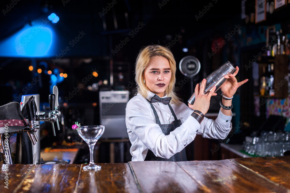 Girl barman makes a cocktail on the beerhouse