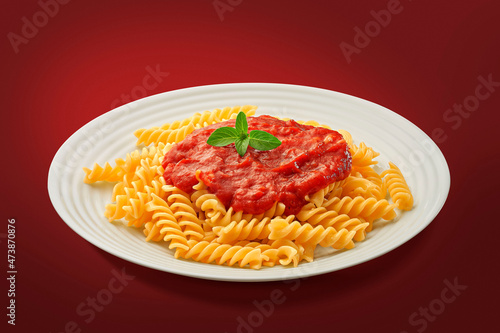 Fusilli ao molho de tomate em fundo vermelho