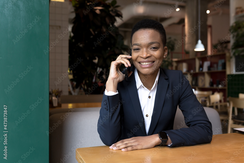 Happy and cheerful woman talking on the phone sitting in a cafe during lunch break, business woman smiling joyfully Happy and cheerful woman talking on the phone sitting in a cafe during lunch break, business woman smiling joyfully