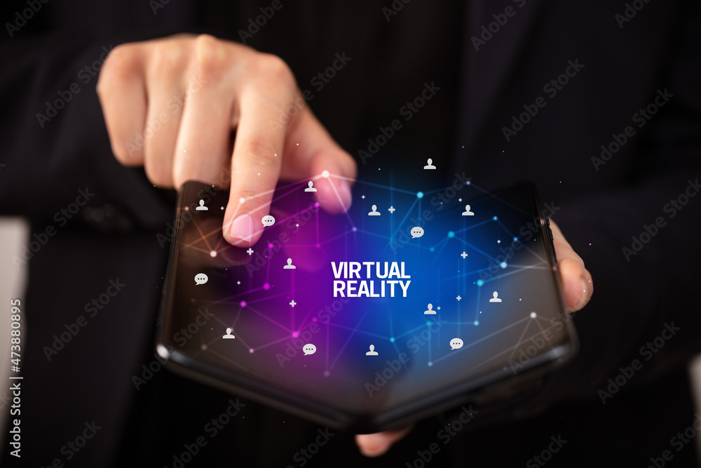 Businessman holding a foldable smartphone, new technology concept Businessman holding a foldable smartphone, new technology concept