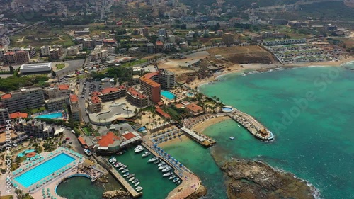 Aerial Panning Residential Buildings On Landscape In City, Drone Flying Over Nautical Vessels In Sea - Batroun, Lebanon photo