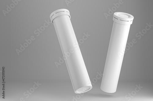 Photos Two round tubular packages for vitamins, aspirin, effervescent medicines on a gray background