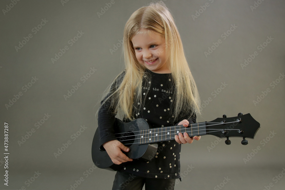 Studio portrait of adorable little girl playing ukulele
Studio portrait of adorable little girl playing ukulele